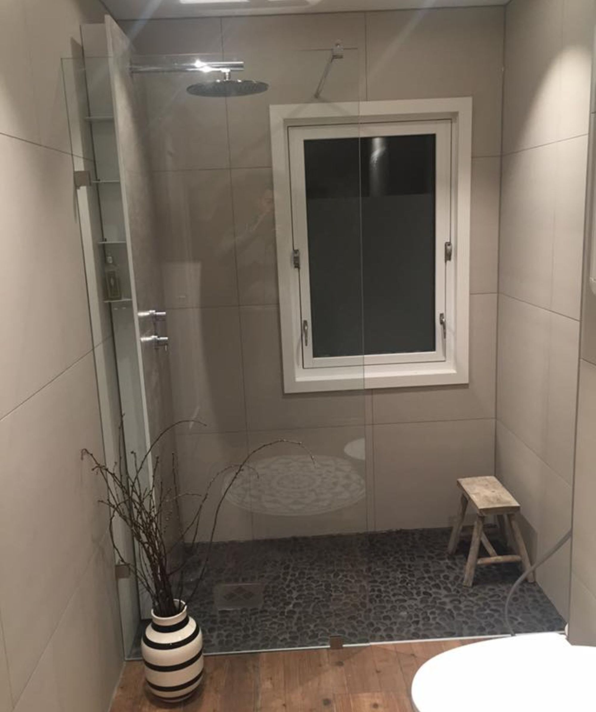 Oppusset bad med dusj, toalett og et vindu