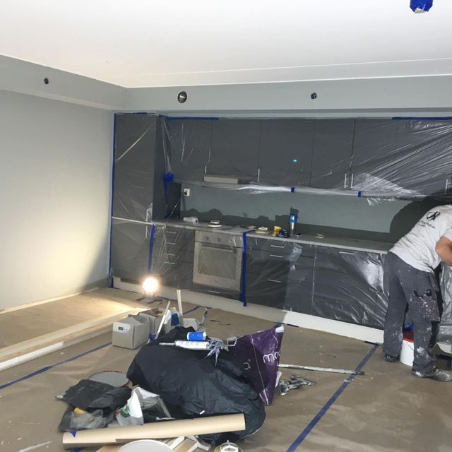En ansatt som installerer et kjøkken i en oppusset leilighet