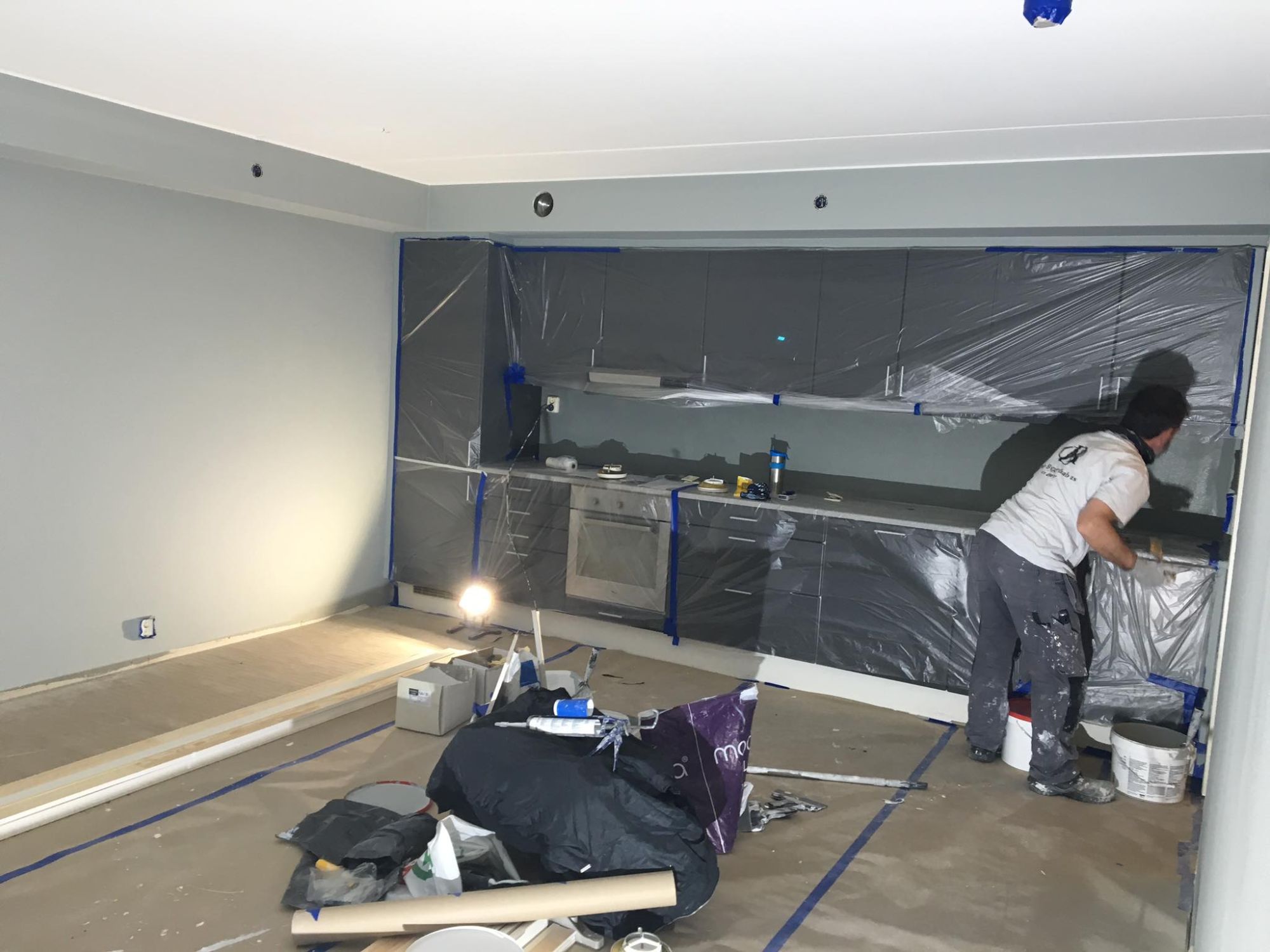 En ansatt som installerer et kjøkken i en oppusset leilighet